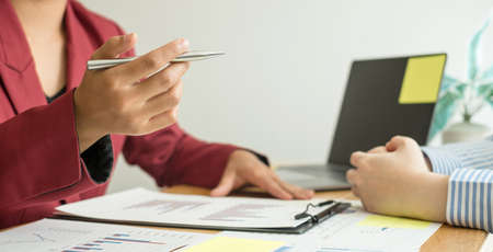 Two business leaders talk about charts, financial graphs showing results are analyzing and...