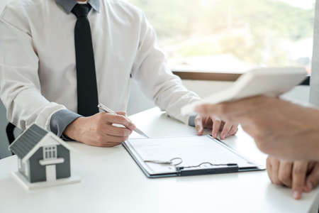 Real estate agents offer sale home insurance and close the sale immediately after the customer signs a purchase contract under a formal agreement. Real Estate Home insurance concept.の写真素材