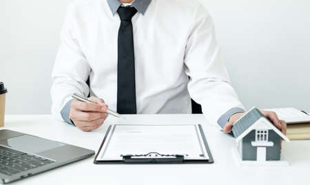 Agents working in real estate investment and home insurance signing contracts in accordance with the...