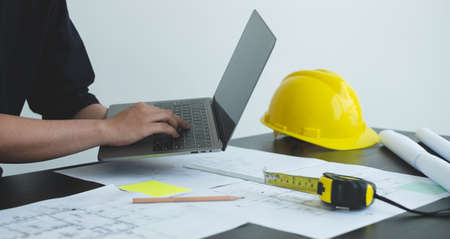 Architects or engineers working construction and drawing construction plans, printing, writing...