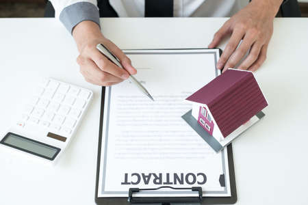 Agents working in real estate investment Hold the key home Ready home insurance signing contracts in accordance with the home buying insurance agreements approving purchases for clients.の写真素材