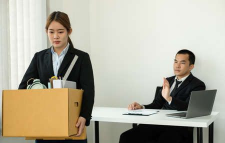 A woman office worker is unhappy with being fired from a company packing things into cardboard...