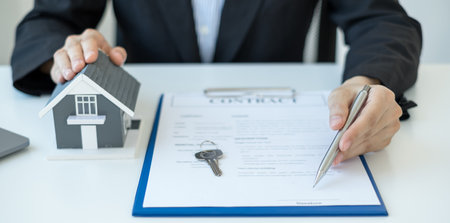 agents working in real estate investment and home insurance signing contracts in accordance with the home buying insurance agreements approving purchases for clients.の写真素材