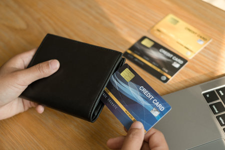 The businesswoman's hand is holding a credit card and using a laptop for online shopping and internet payment.の写真素材