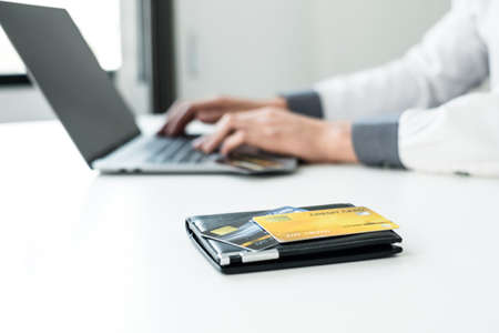 The businessman's hand is holding a credit card and using a laptop for online shopping and internet payment.の写真素材