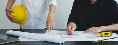 Team of engineers and architects, working team, meeting, discussing construction and drawing construction plans, printing, writing on-site construction sites. Home design concept.の写真素材