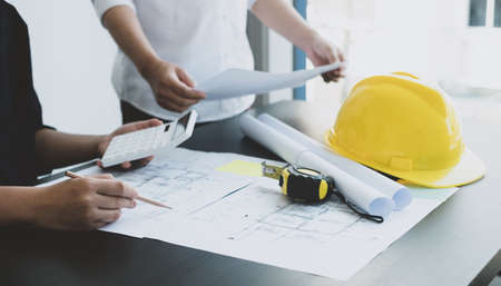 Team of engineers and architects, working team, meeting, discussing construction and drawing construction plans, printing, writing on-site construction sites. Home design concept.の写真素材