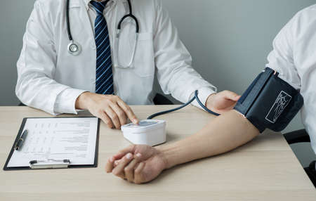 Man doctors measured blood pressure, the patient examined the heartbeat, and talked about health care closely. Medical and health care concepts.の写真素材