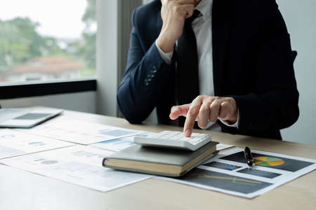 The hand of businessman sit at their desks and calculate financial graphs showing results about their investments, plan a successful business growth process.の写真素材