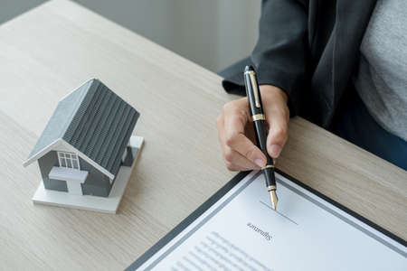 agents working in real estate investment and home insurance signing contracts in accordance with the home buying insurance agreements approving purchases for clients.の写真素材