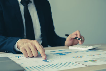 The hand of businessman sit at their desks and calculate financial graphs showing results about their investments, plan a successful business growth process.の写真素材