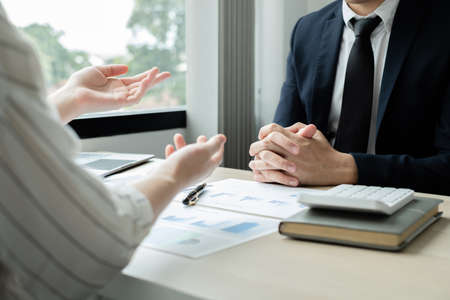 Two business leaders talk about charts, financial graphs showing results are analyzing and calculating planning strategies, business success building processes.の写真素材