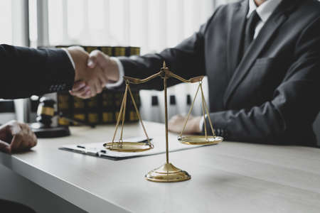 shake hand Professional man lawyers work at a law office There are scales, Scales of justice, judges gavel, and litigation documents. Concepts of law and justice.の写真素材