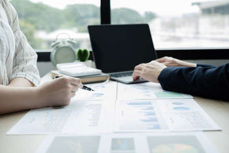 Two business leaders talk about charts, financial graphs showing results are analyzing and calculating planning strategies, business success building processes.の写真素材