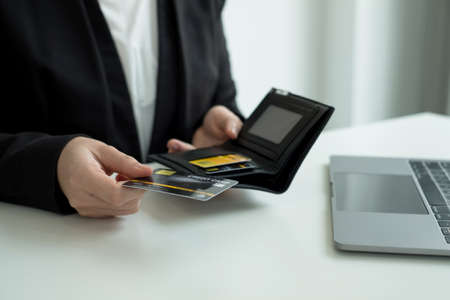 The businesswomen's hand is holding a credit card and using a laptop for online shopping and internet payment.の写真素材