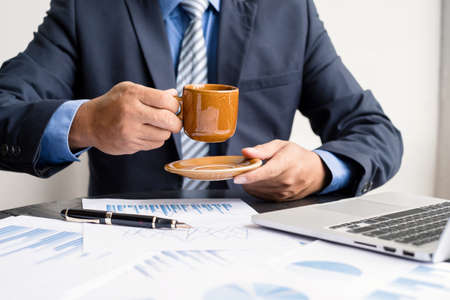 work from home, The hand of the businessman who works in finance at home and calculates financial graphs showing the results of his investments, planning the steps of his business growth.の写真素材