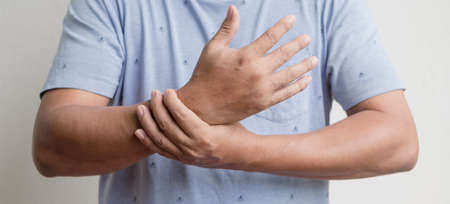Man hand with numbness and pain in the wrist has pain and tingling in the nerve endings. which is a side effect of Guillain-Barre Syndrome after vaccination against COVID-19.の写真素材