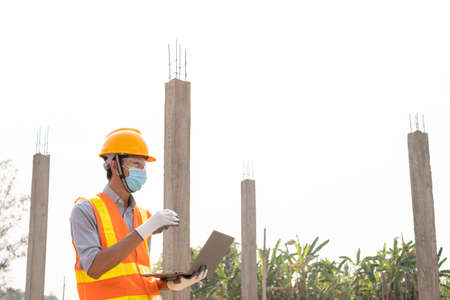 The construction site male engineer or architect is exploring and inspecting the outdoor...