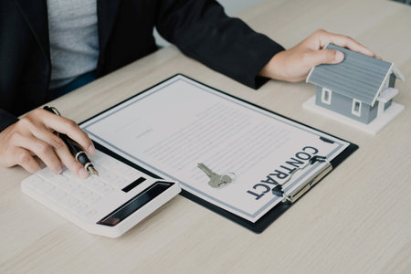 agents working in real estate investment and home insurance signing contracts in accordance with the home buying insurance agreements approving purchases for clients.の写真素材