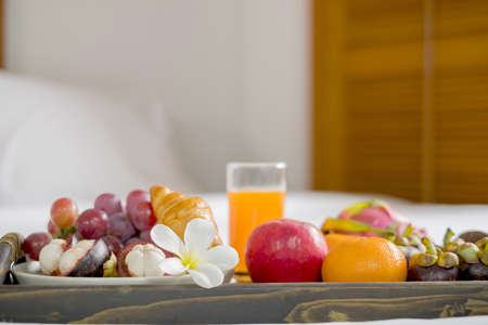 Focus on fruit. In a hotel room with fruit, place a tray on the bed to welcome the arrival of VIP guests.の写真素材