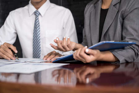 Two business leaders talk about charts, financial graphs showing results are analyzing and calculating planning strategies, business success building processes.の写真素材