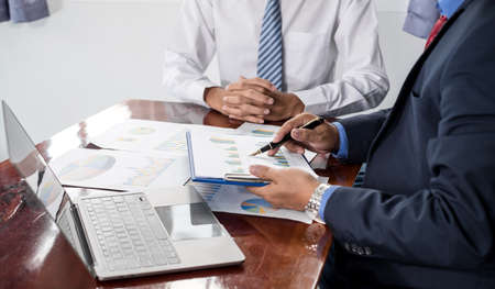 Two business leaders talk about charts, financial graphs showing results are analyzing and calculating planning strategies, business success building processes.の写真素材