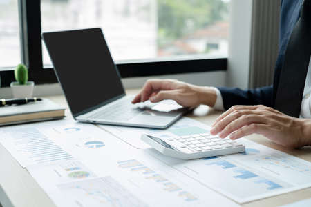 The hand of businessman sit at their desks and calculate financial graphs showing results about their investments, plan a successful business growth process.の写真素材