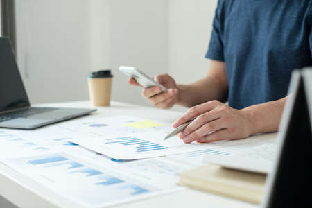 work from home, The hand of a man who works in finance sits at his desk at home and calculates...