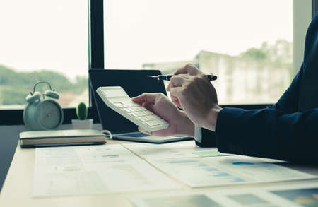 The hand of businessman sit at their desks and calculate financial graphs showing results about their investments, plan a successful business growth process.の写真素材