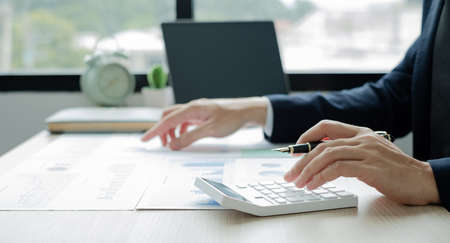 The hand of businessman sit at their desks and calculate financial graphs showing results about their investments, plan a successful business growth process.の写真素材