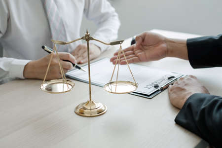 A man lawyer or a judge counseling clients about judicial justice and prosecution with scales,...