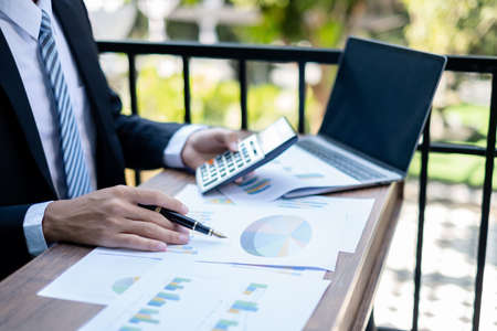Young businessman financial market analyst sits at their desks and calculate financial graphs showing the results of their investments planning the process of successful business growth.の写真素材