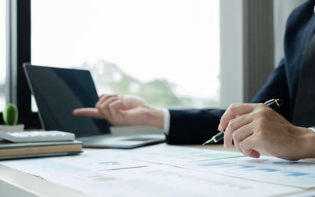 The hand of businessman sit at their desks and calculate financial graphs showing results about their investments, plan a successful business growth process.の写真素材