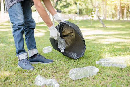 garbage collection, Man's hands pick up plastic bottles, put garbage in black garbage bags to clean...