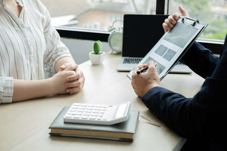 Two business leaders talk about charts, financial graphs showing results are analyzing and calculating planning strategies, business success building processes.の写真素材