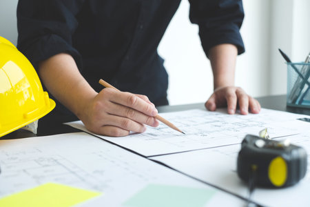 Architects or engineers working construction and drawing construction plans, printing, writing...