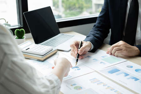 Two business leaders talk about charts, financial graphs showing results are analyzing and calculating planning strategies, business success building processes.の写真素材