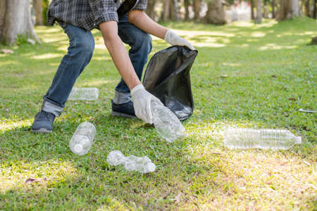 garbage collection, Man's hands pick up plastic bottles, put garbage in black garbage bags to clean...