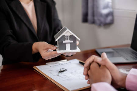 Real estate agent broker hand over the home to the new owner after completing the signing according...