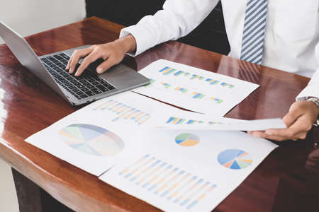 The businessman hand sits at their desks and calculates financial graphs showing the results of their investments planning the process of successful business growth.の写真素材