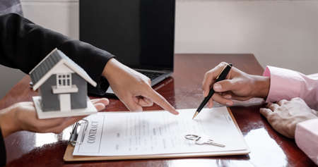Real estate agent broker hand over the home to the new owner after completing the signing according...
