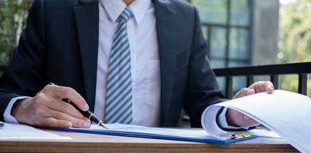 Young businessman financial market analyst sits at their desks and calculate financial graphs showing the results of their investments planning the process of successful business growth.の写真素材