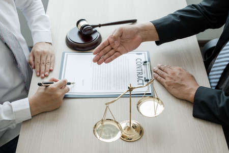 A man lawyer or a judge counseling clients about judicial justice and prosecution with scales, judges gavel, legal documents legal services concept.の写真素材