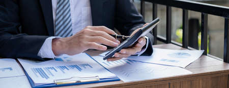Young businessman financial market analyst sits at their desks and calculate financial graphs showing the results of their investments planning the process of successful business growth.の写真素材