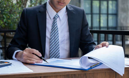 Young businessman financial market analyst sits at their desks and calculate financial graphs showing the results of their investments planning the process of successful business growth.の写真素材