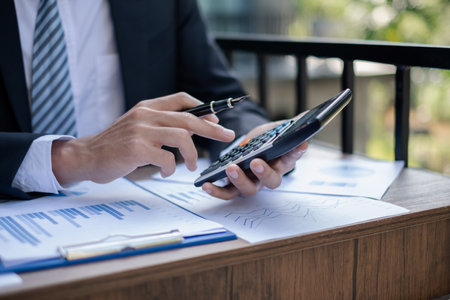 Young businessman financial market analyst sits at their desks and calculate financial graphs...