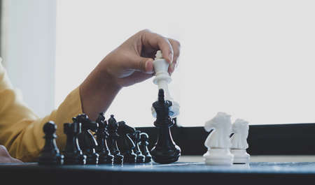 Hand of businesswoman moving, chess in competition shows leadership, followers, and business success strategies.の写真素材
