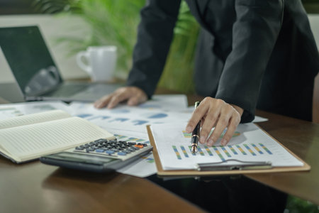 The businesswoman hand sits at their desks and calculates financial graphs showing the results of their investments planning the process of successful business growth.の写真素材