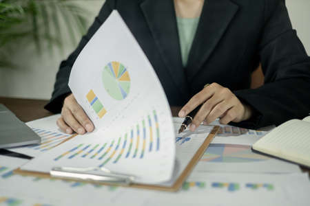 The businesswoman hand sits at their desks and calculates financial graphs showing the results of their investments planning the process of successful business growth.の写真素材