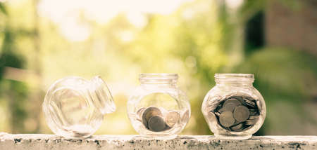 Retirement savings concept. bottle glass and coins with green nature background and copy space.